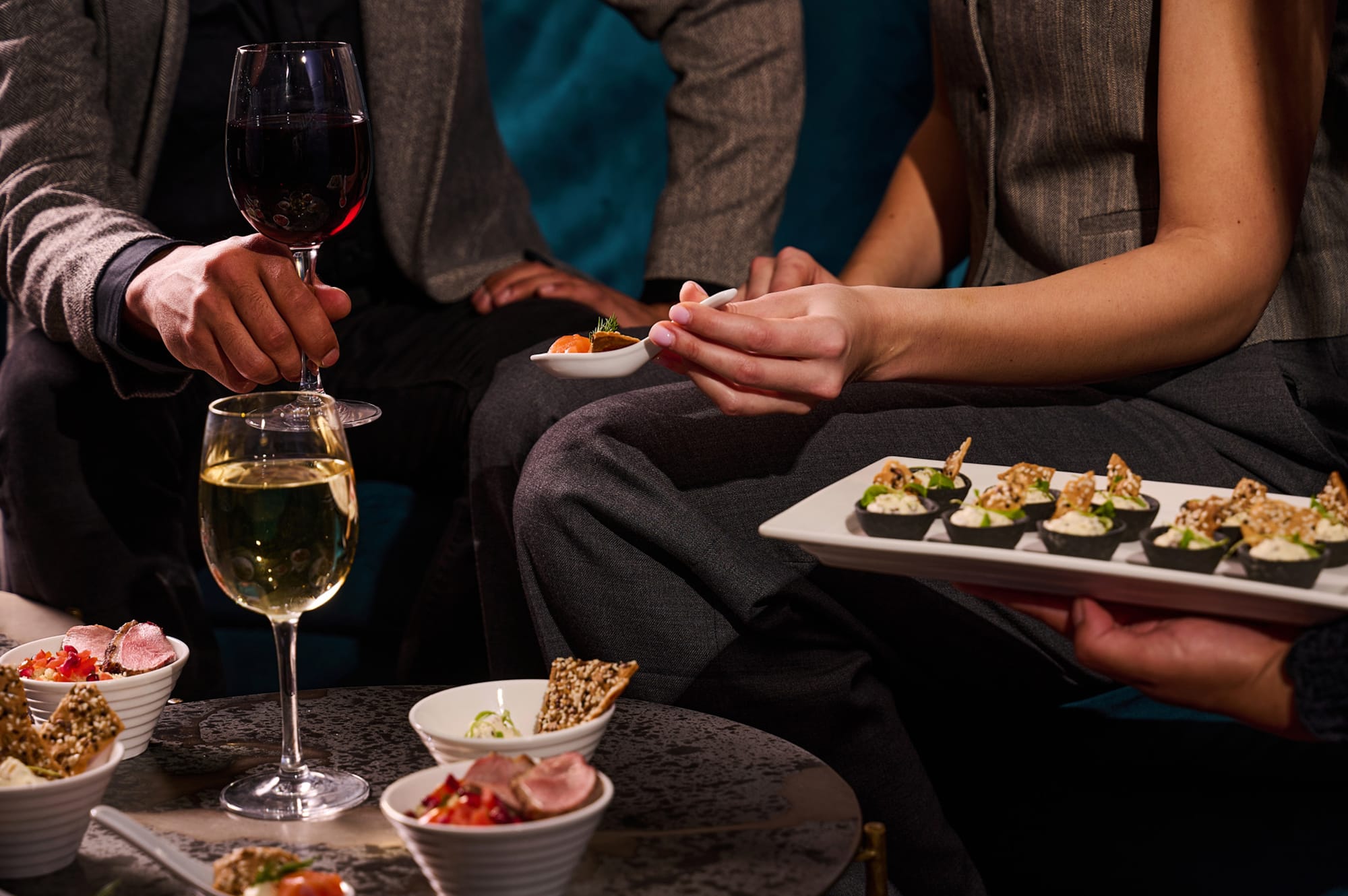 Benugo at London Coliseum - two people sharing several small plates of food with wine in the Adelaide's Bar.