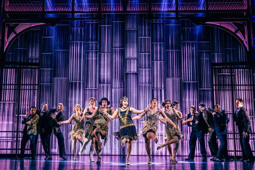 Dancers from the cast of The Great Gatsby performing against a purple stage set