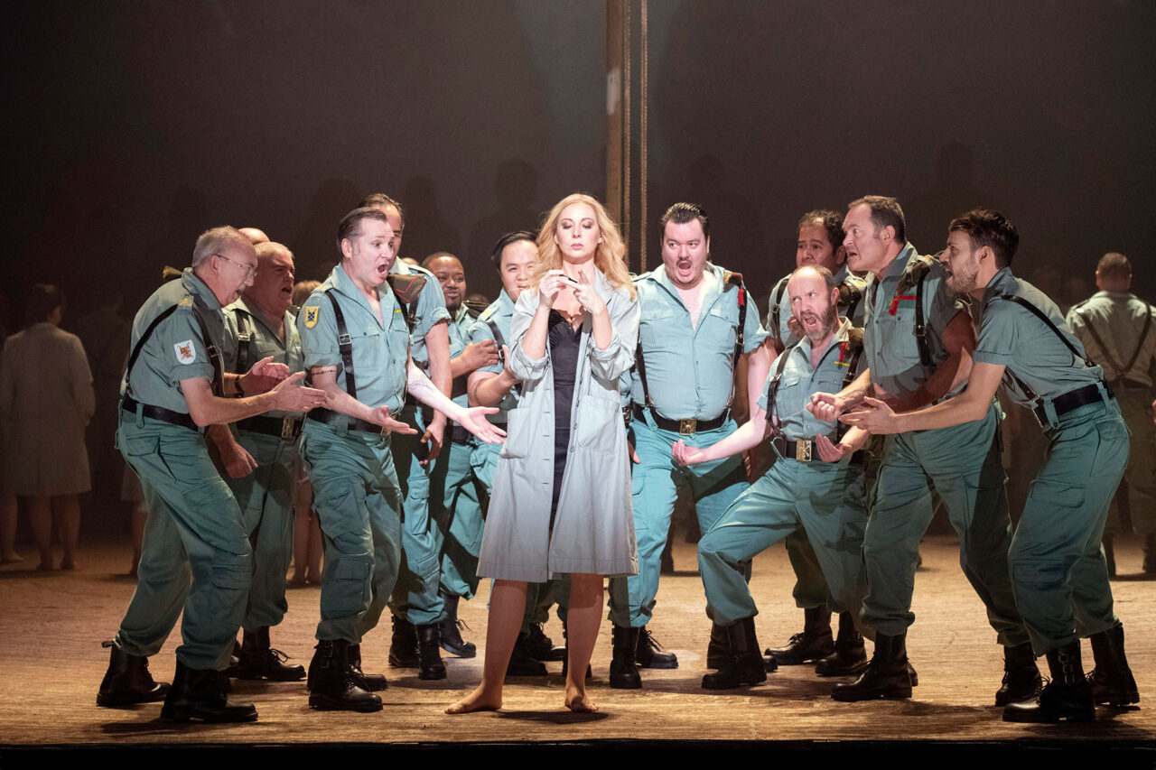 The cast of Carmen on stage at the London Coliseum. Carmen standing centre surrounded by male characters
