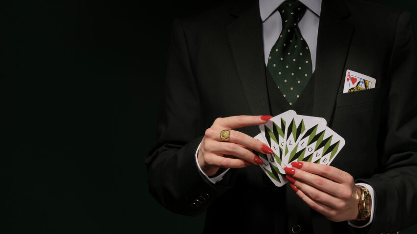 Production image of person holding playing cards for ENO's 2025 production of Partenope